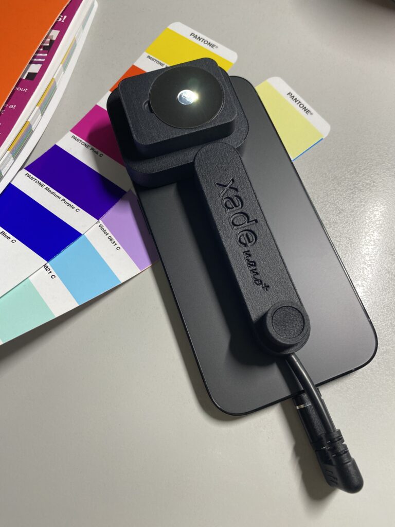 De xade nano+ op een iPhone 14 Pro. De meetkop, die van stroom wordt voorzien via de Lightning- of USB-C-aansluiting, is duidelijk zichtbaar.